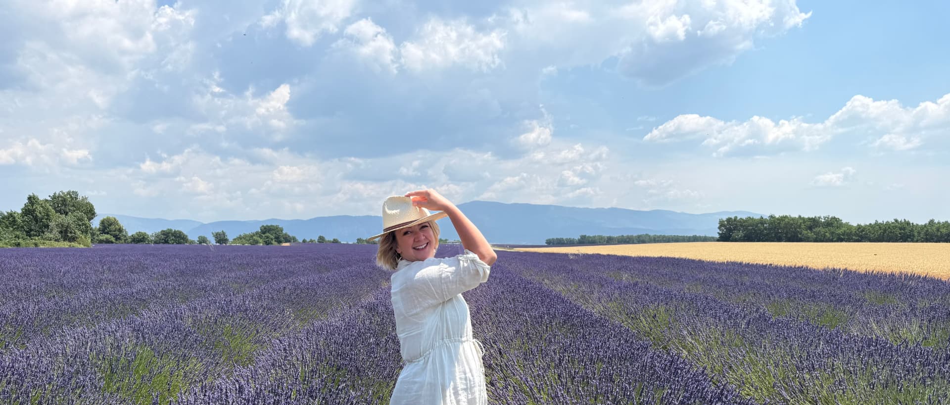 D LeD standing in a lavender field, turning back with a smile